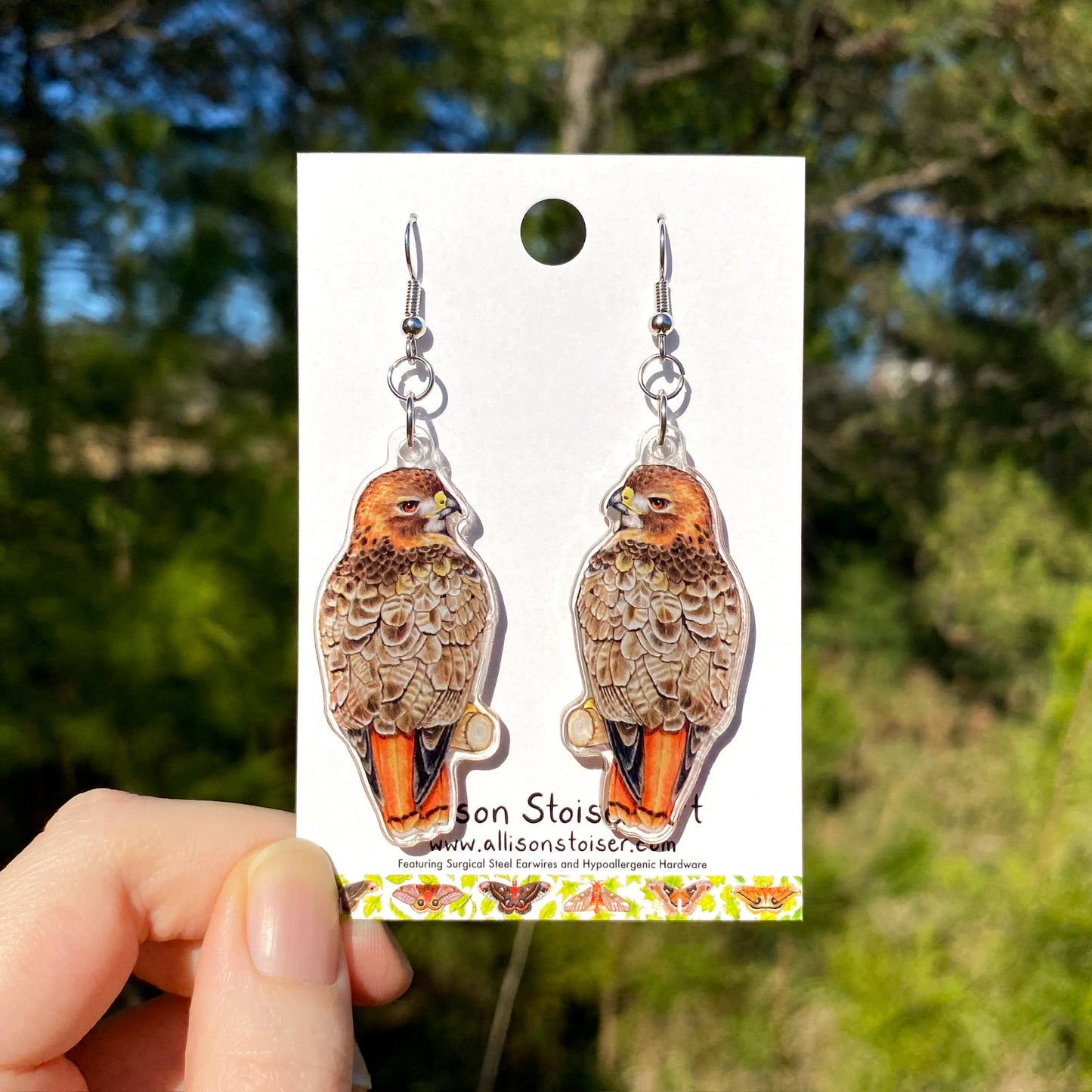 acrylic earrings with red-tailed hawk charms