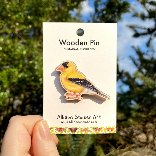 A wooden pin of an American goldfinch
