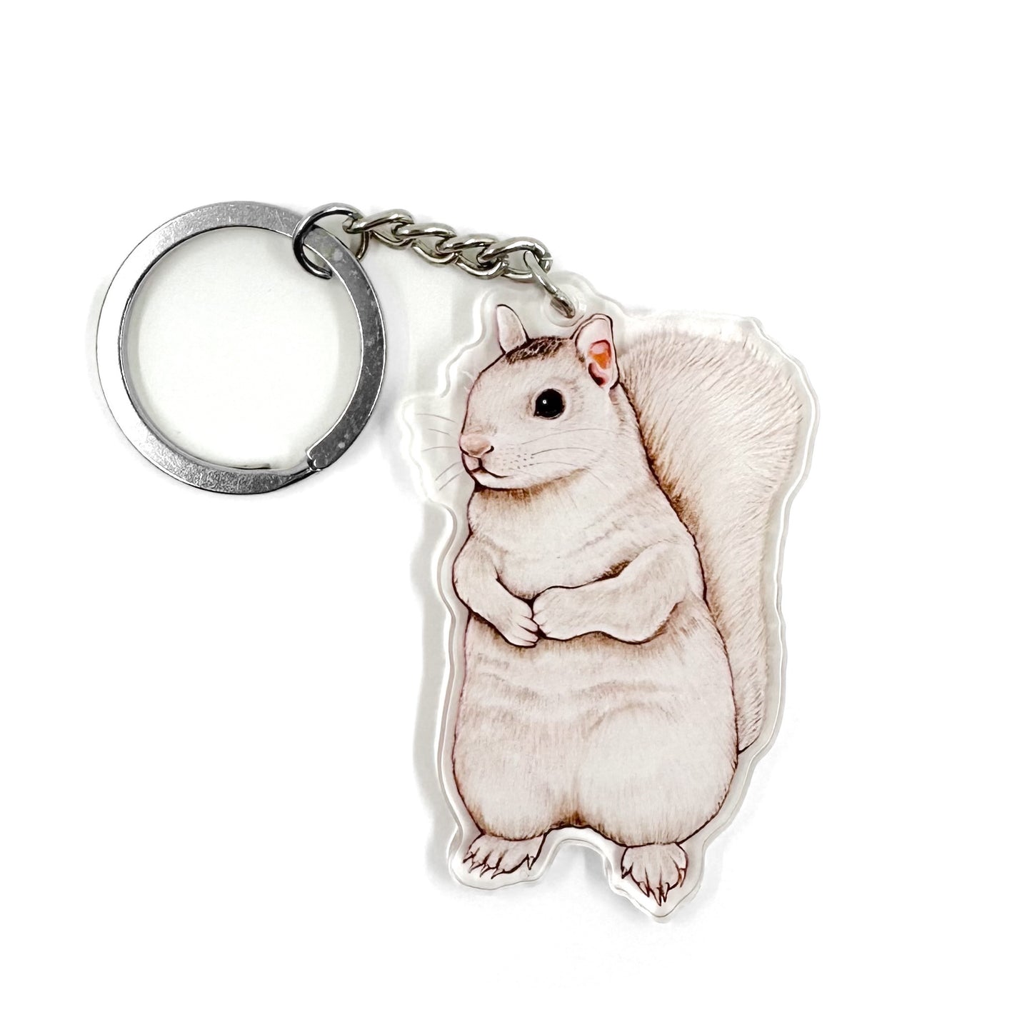 A keychain featuring an illustration of a white squirrel