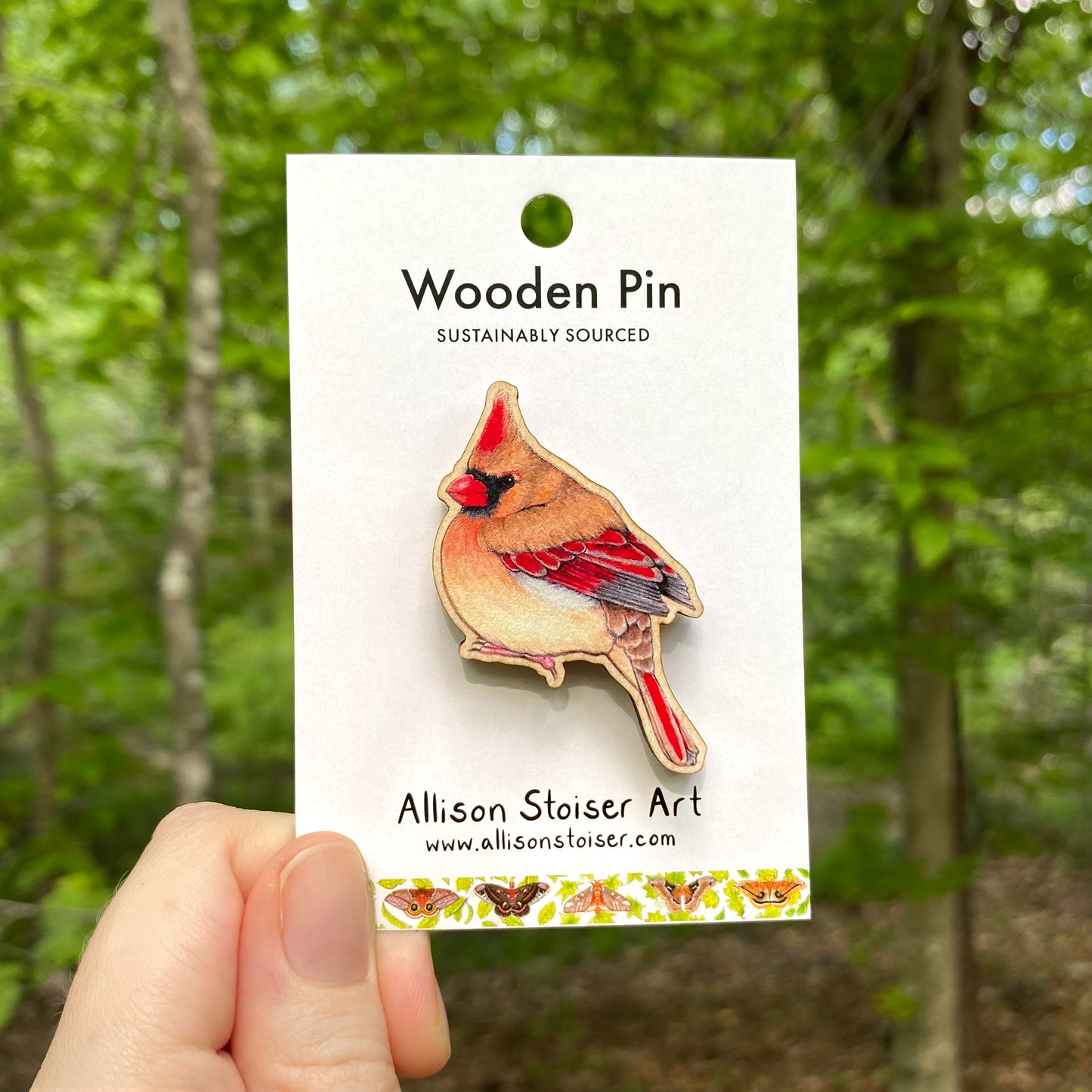 A wooden pin of a female northern cardinal