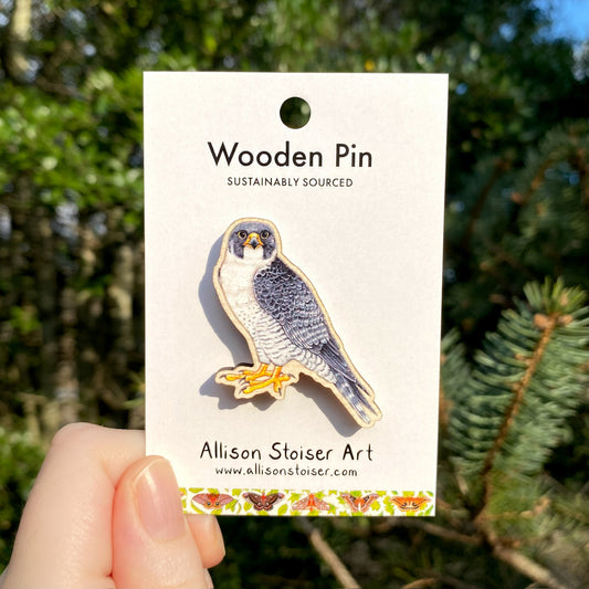 A wooden pin of a peregrine falcon