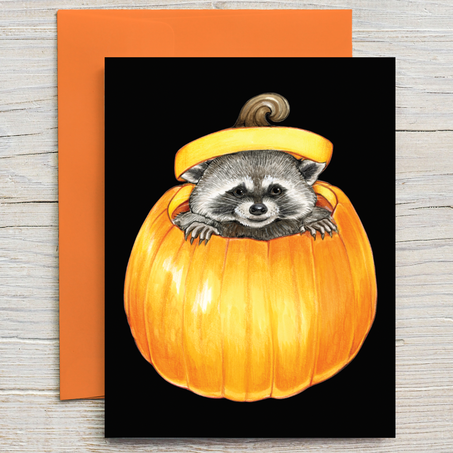 This card features an illustration of a mischievous raccoon peeking out from a pumpkin.  