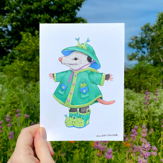 Illustration of an opossum in a green raincoat held in front of a natural background with trees and flowers.