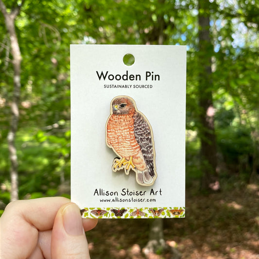 A wooden pin of a red-shouldered hawk