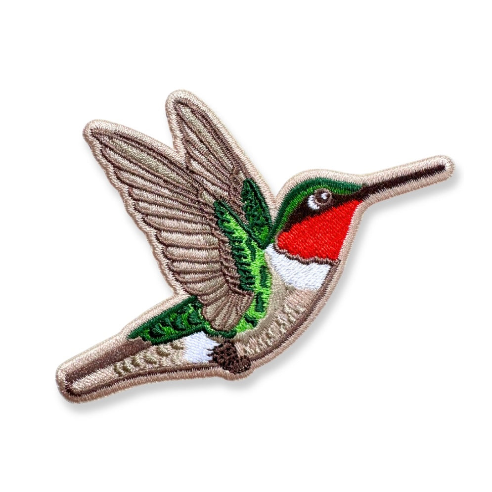 An embroidered hummingbird patch shown on a plain white background. The patch features a brown and beige body and wings, a green head and tail, a bright red chest, and a white underbelly.
