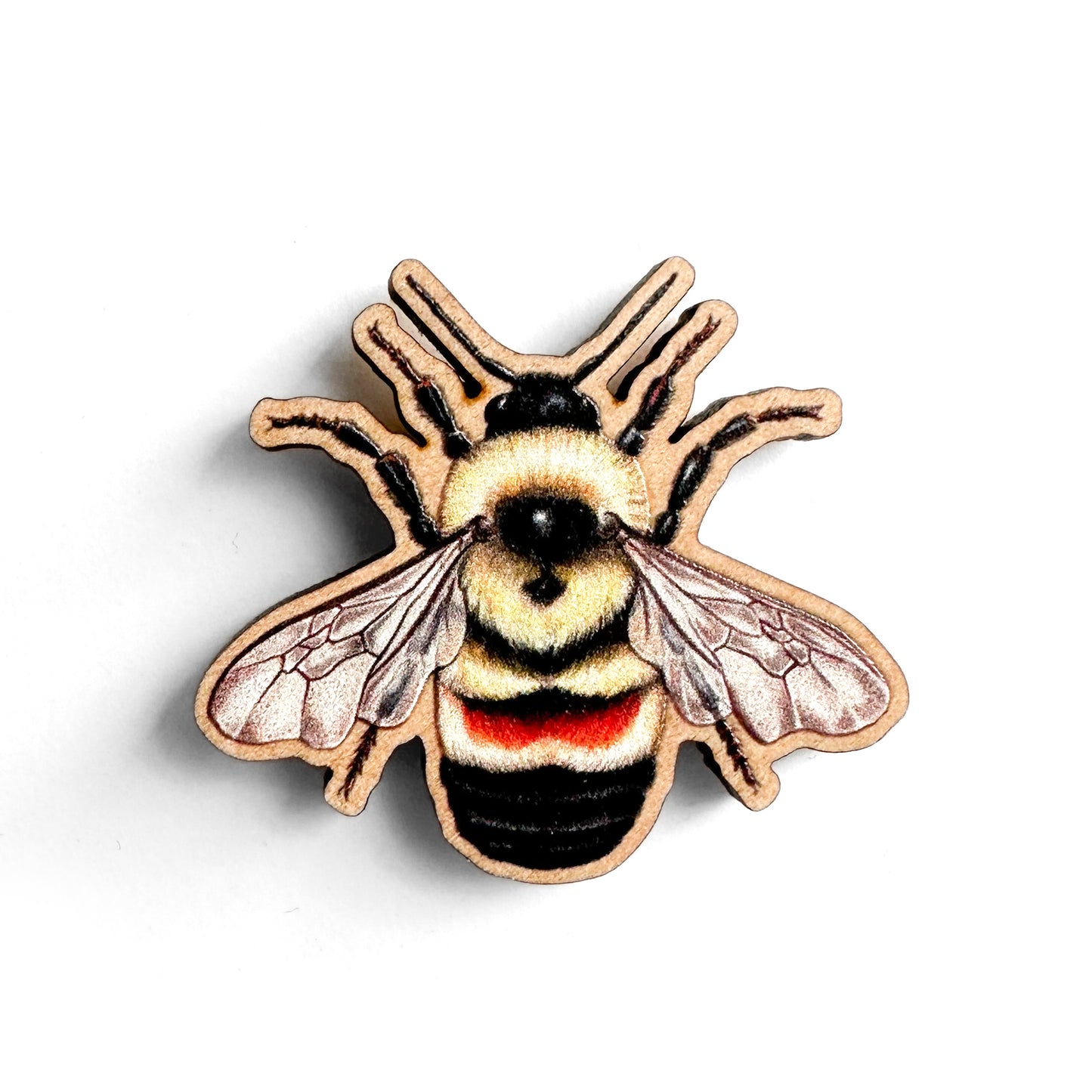 A wooden pin of a rusty-patched bumble bee on a white background.