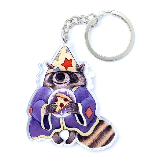 A keychain of a raccoon dressed up as a wizard holding a crystal ball with pizza within