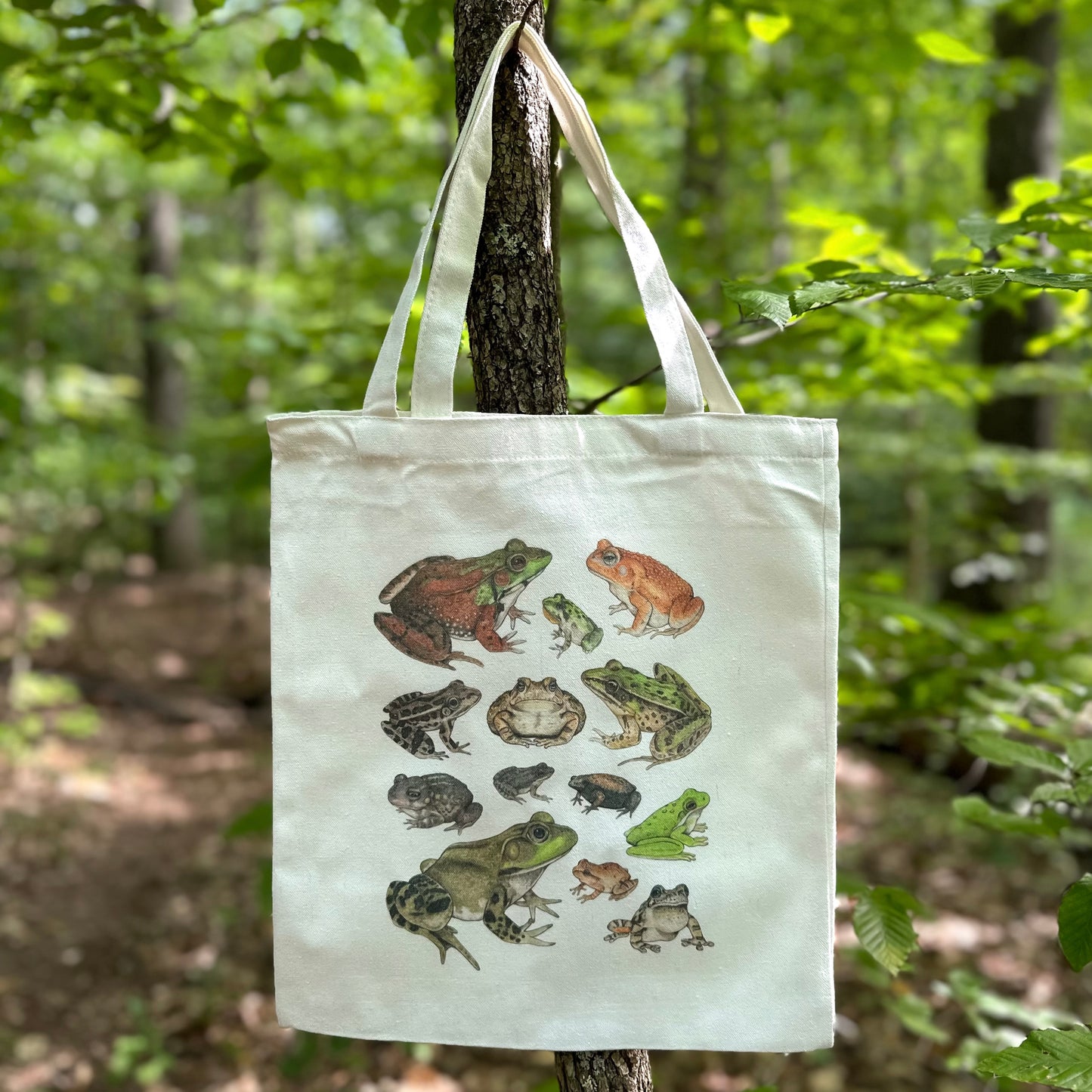 A tote bag featuring an illustration of frogs and toads