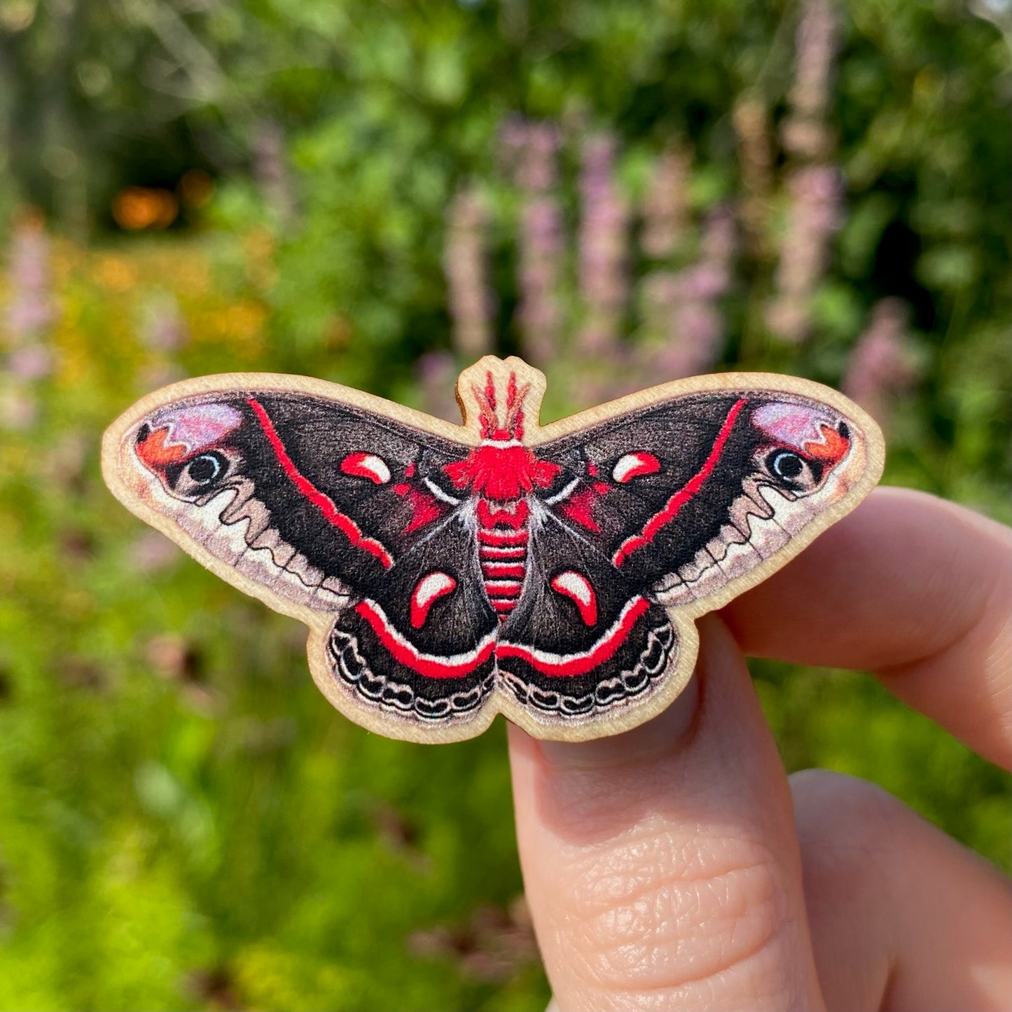 A sustainably sourced wooden pin featuring a cecropia moth