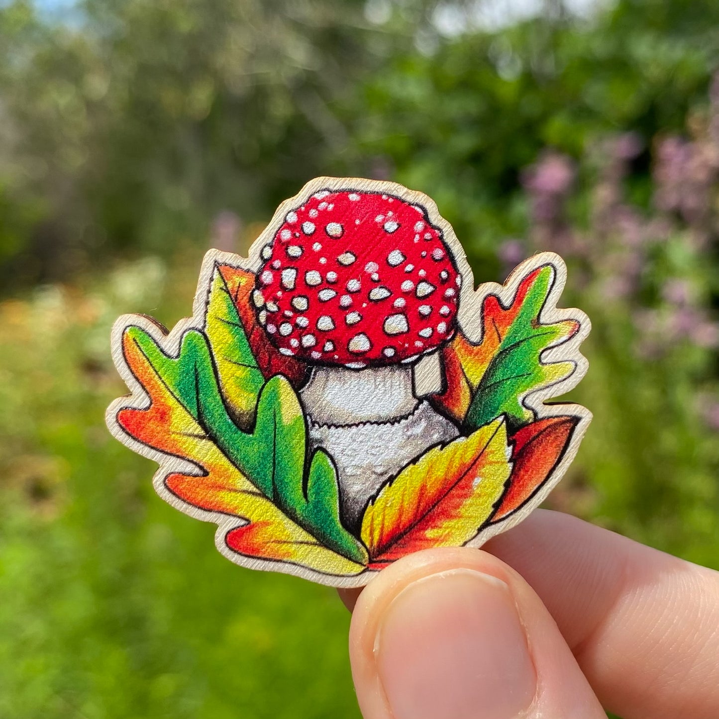 A sustainably sourced pin featuring an illustration of a fly agaric mushroom