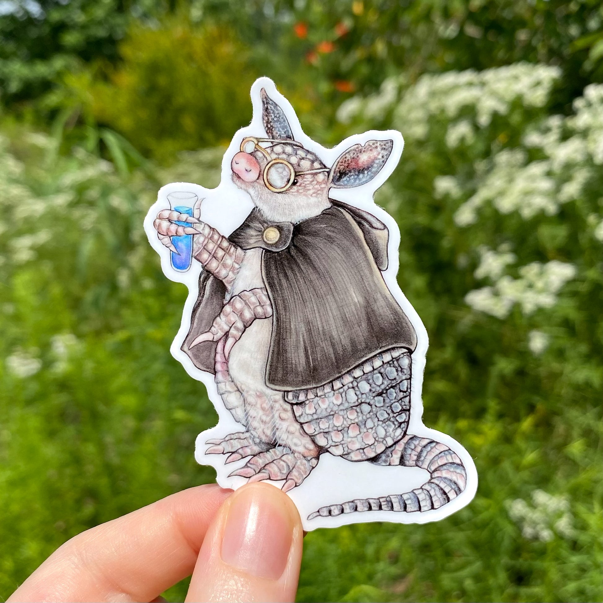 A sticker featuring an illustration of an armadillo working as an alchemist