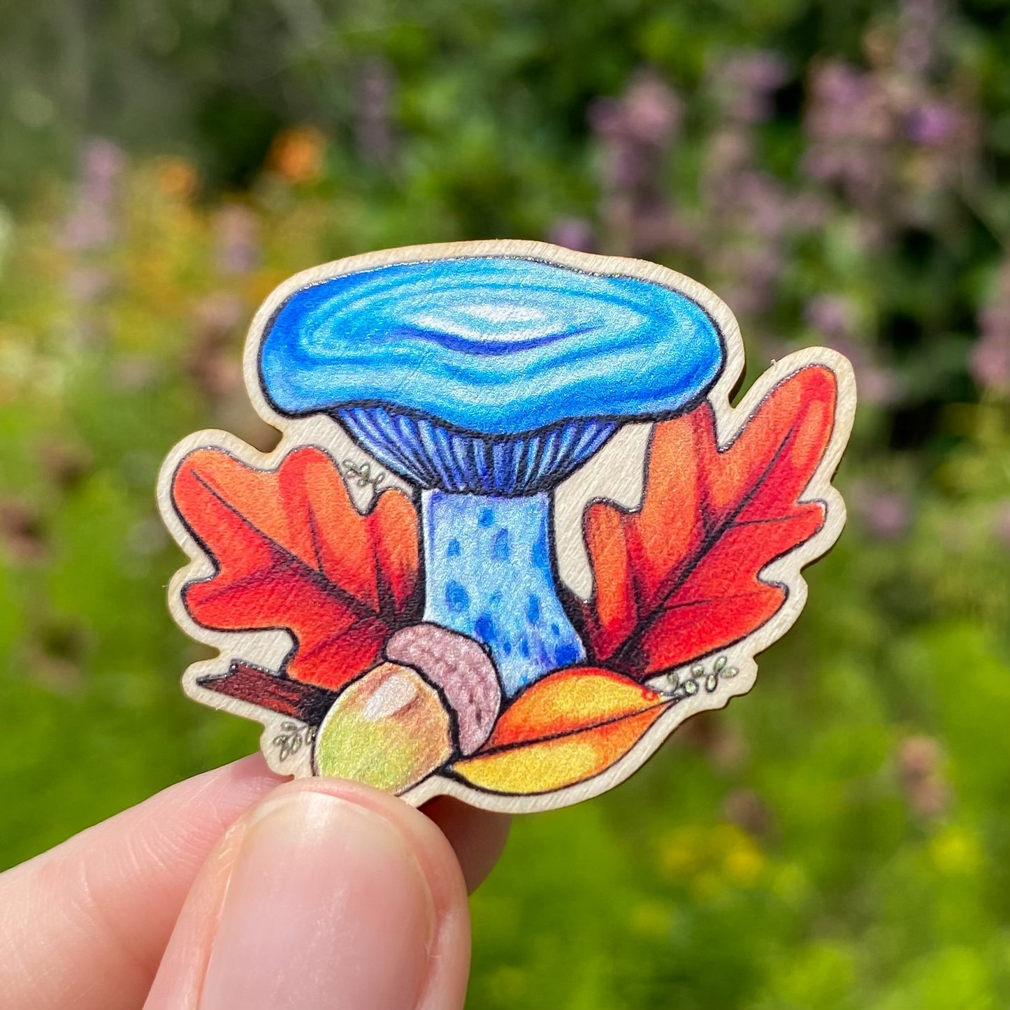 A sustainably sourced pin featuring an illustration of an indigo milkcap mushroom
