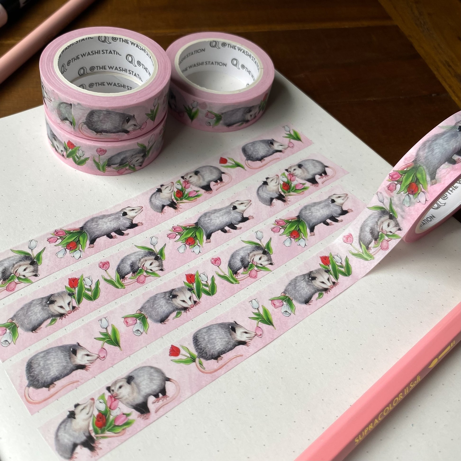 Washi tape featuring opossums and tulips swatched on a notebook page