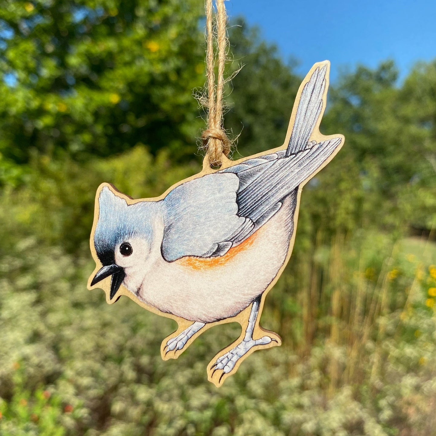 A wooden ornament strung with twine of a tufted titmouse.