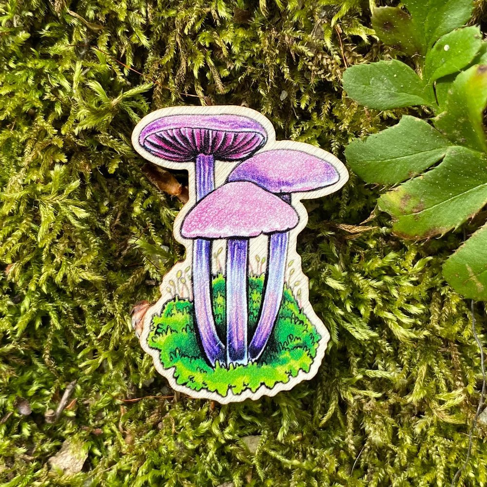 A sustainably sourced pin featuring an illustration of an amethyst deceiver mushroom