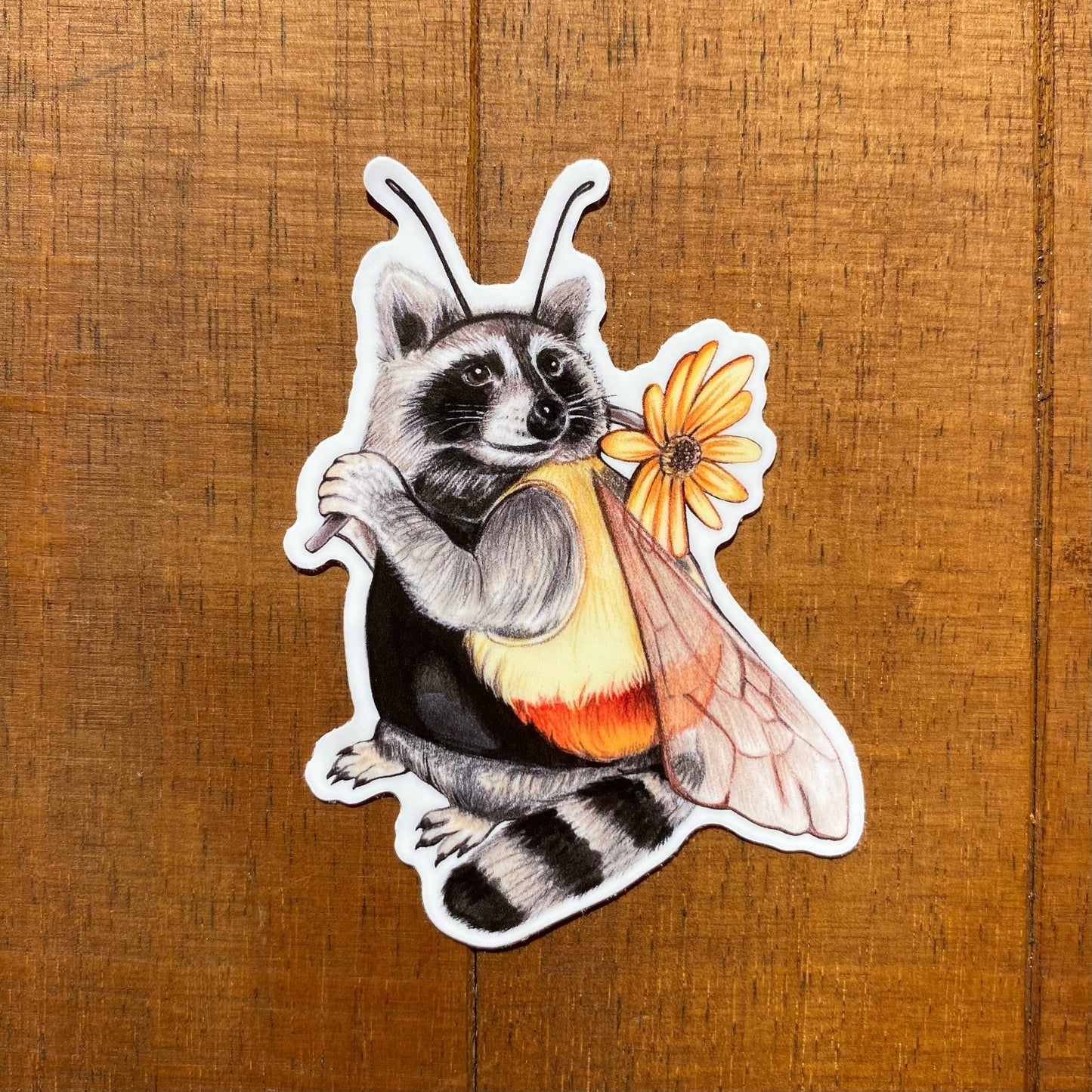 A weatherproof vinyl sticker featuring an illustration of a raccoon dressed as a bee