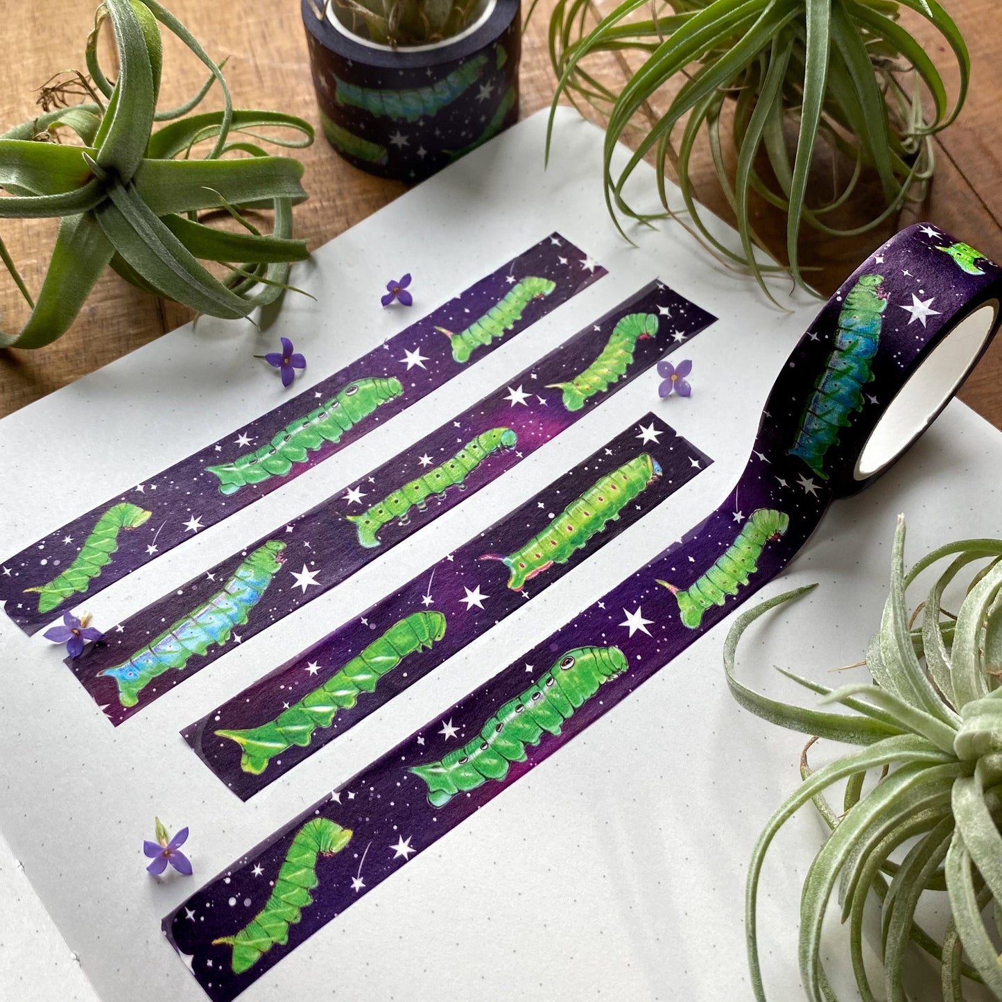 Washi tape featuring sphingid caterpillars on a cosmic background swatched in a notebook