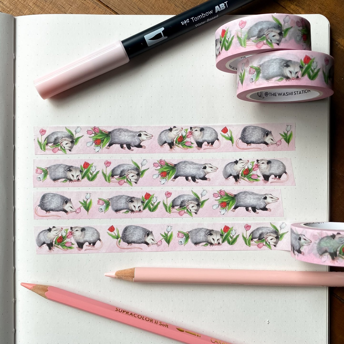 Washi tape featuring opossums and tulips swatched on a notebook page