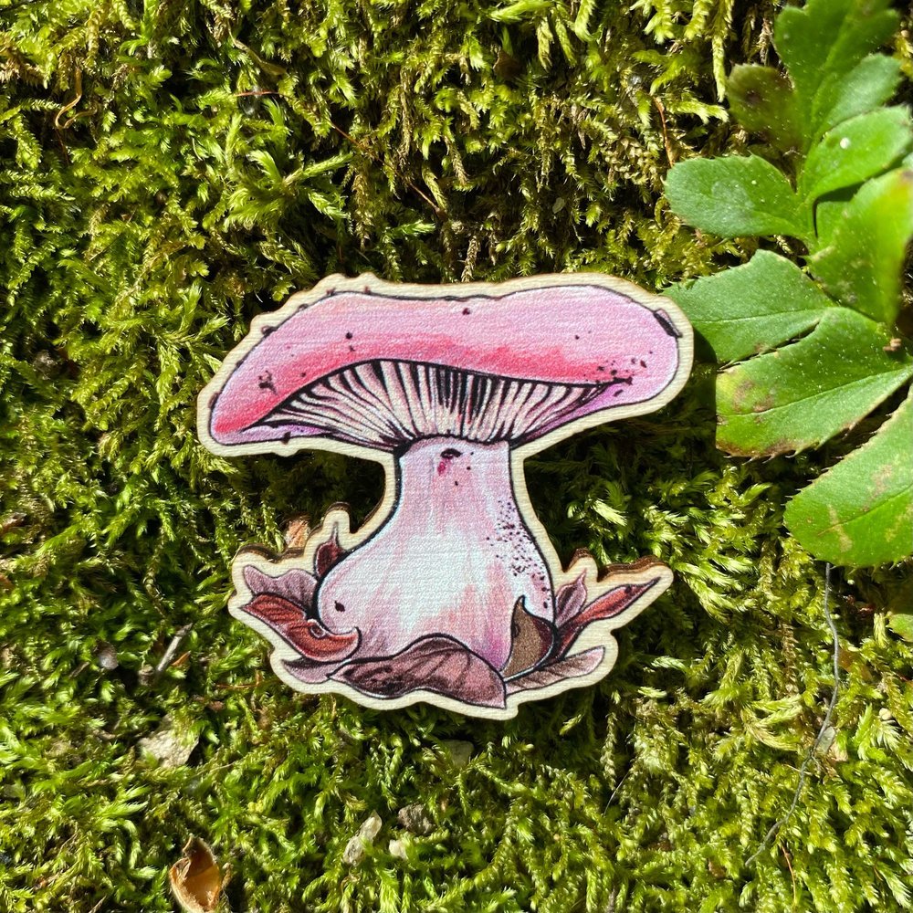 A sustainably sourced pin featuring an illustration of a wood blewit mushroom