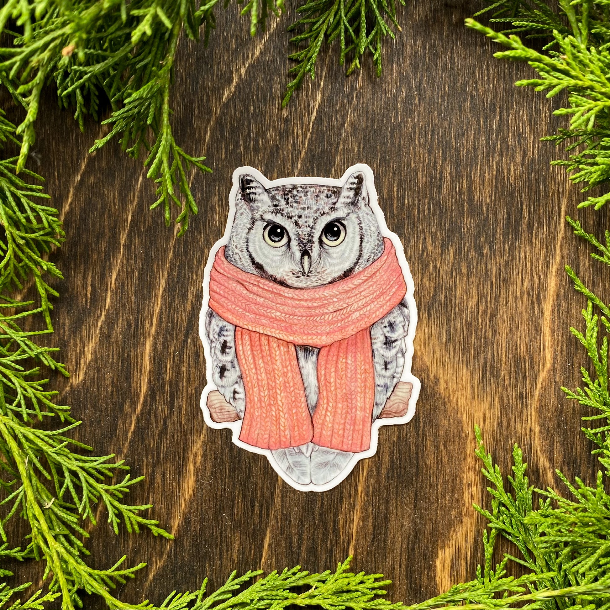 A weatherproof sticker featuring an illustration of an eastern screech owl wearing a scarf