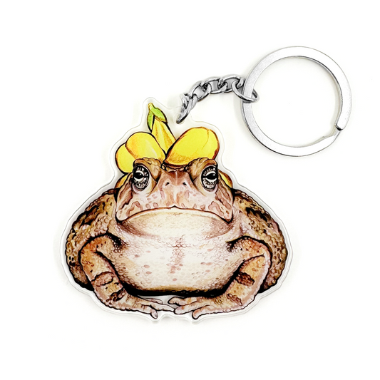 A keychain featuring an illustration of a Fowler's toad wearing a flower hat