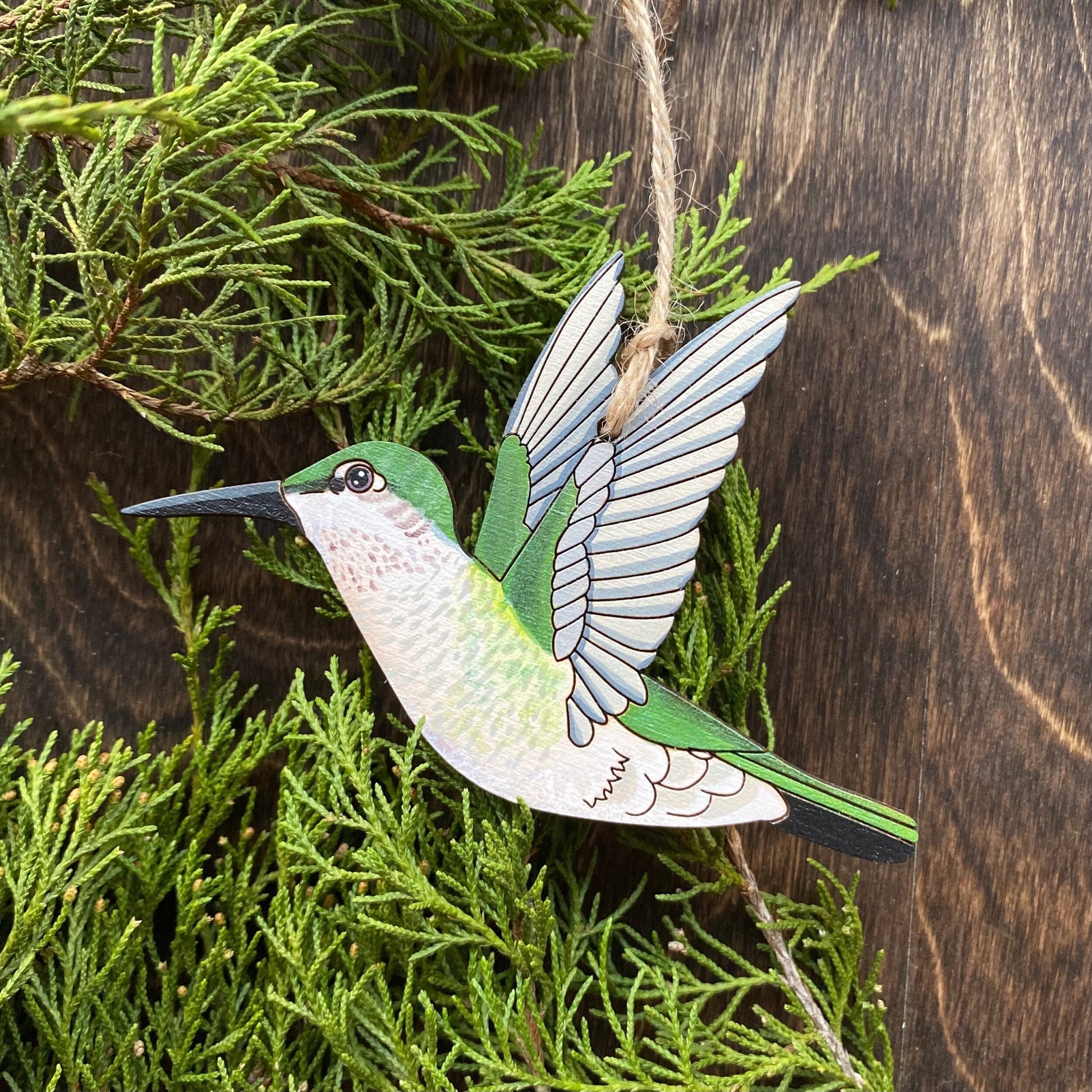 A hand-painted ornament featuring a female ruby throated hummingbird