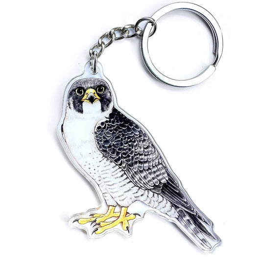 A keychain of a peregrine falcon on a white background.