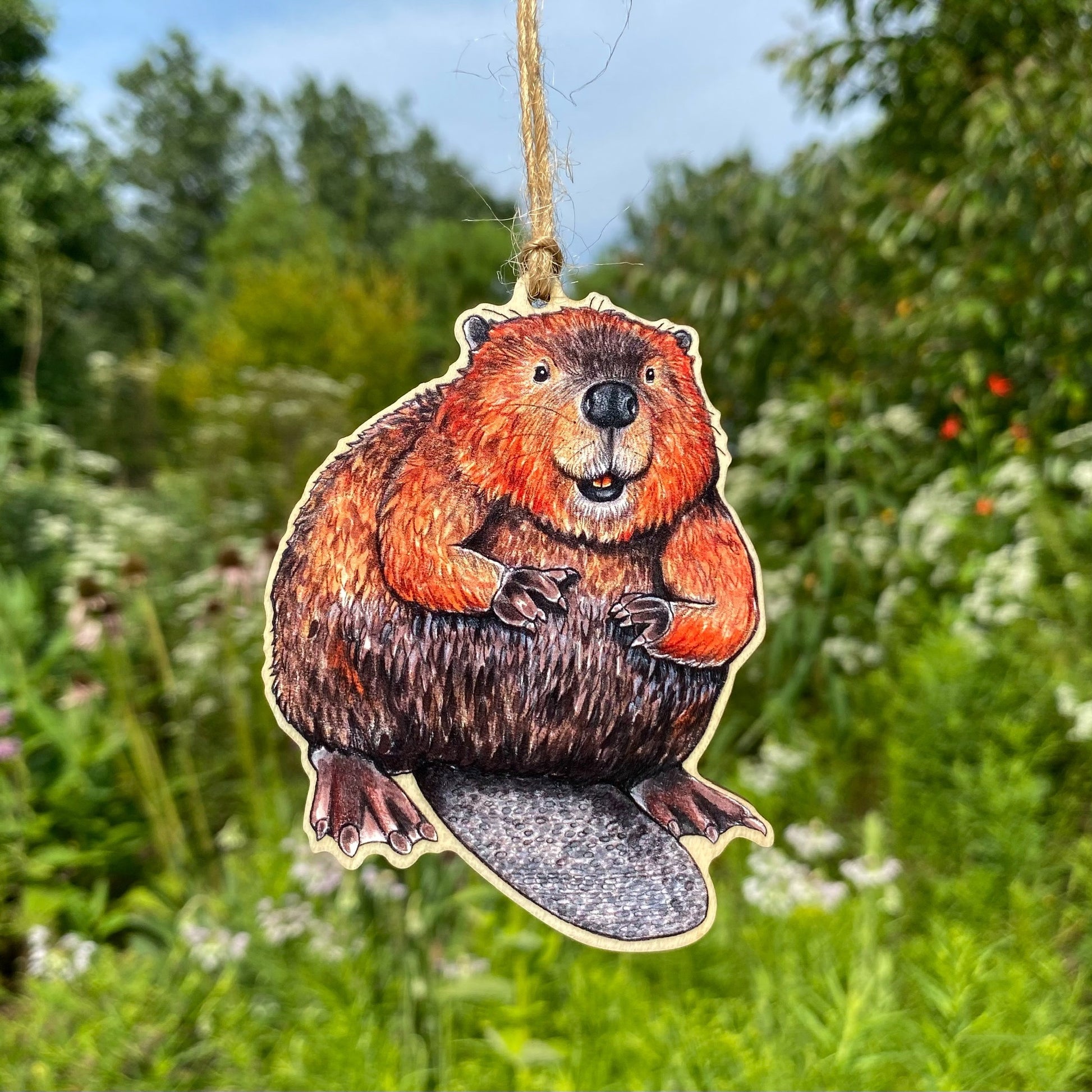 A wooden ornament strung with twine of an American beaver.