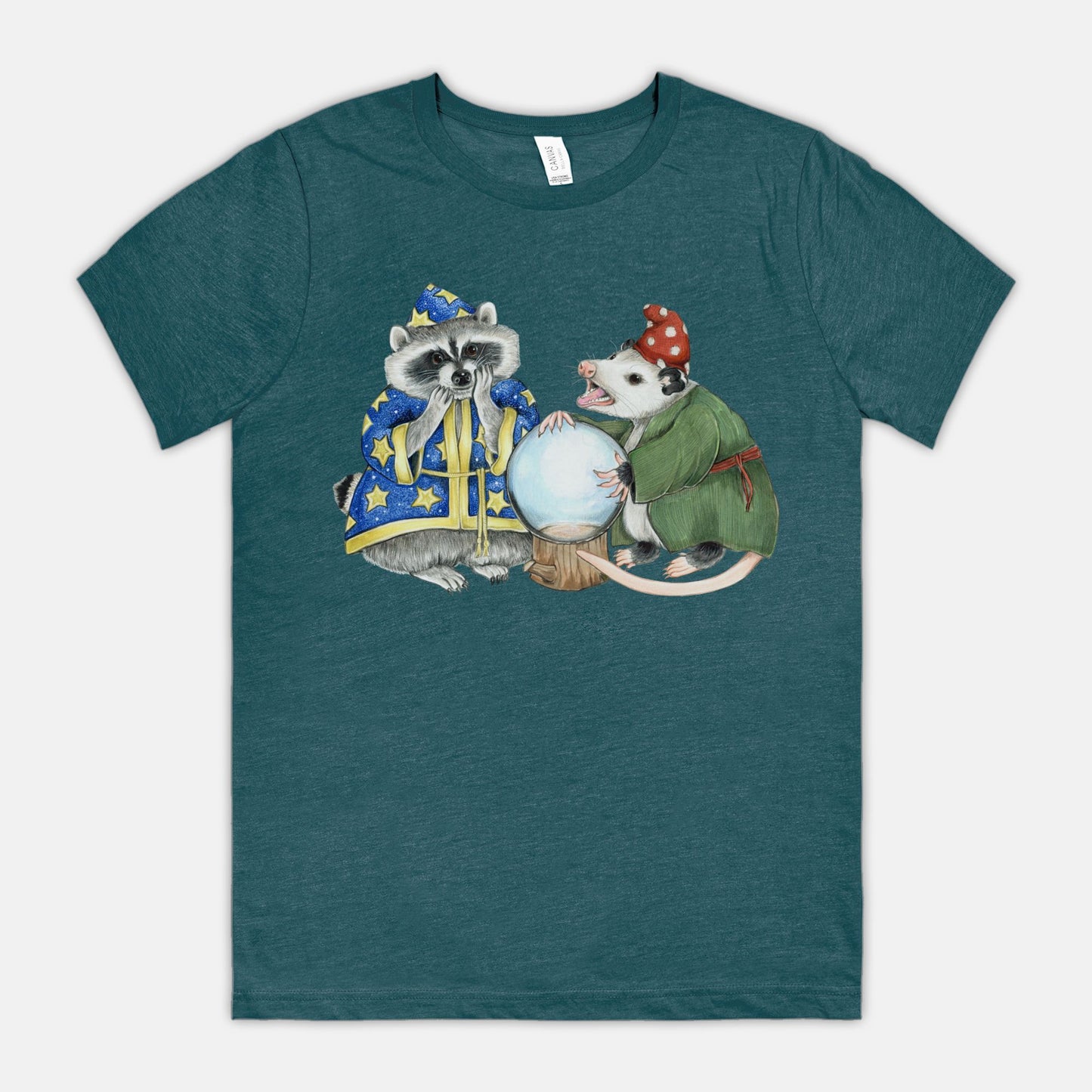 A teal t-shirt featuring an illustration of a raccoon wizard and opossum fortune teller