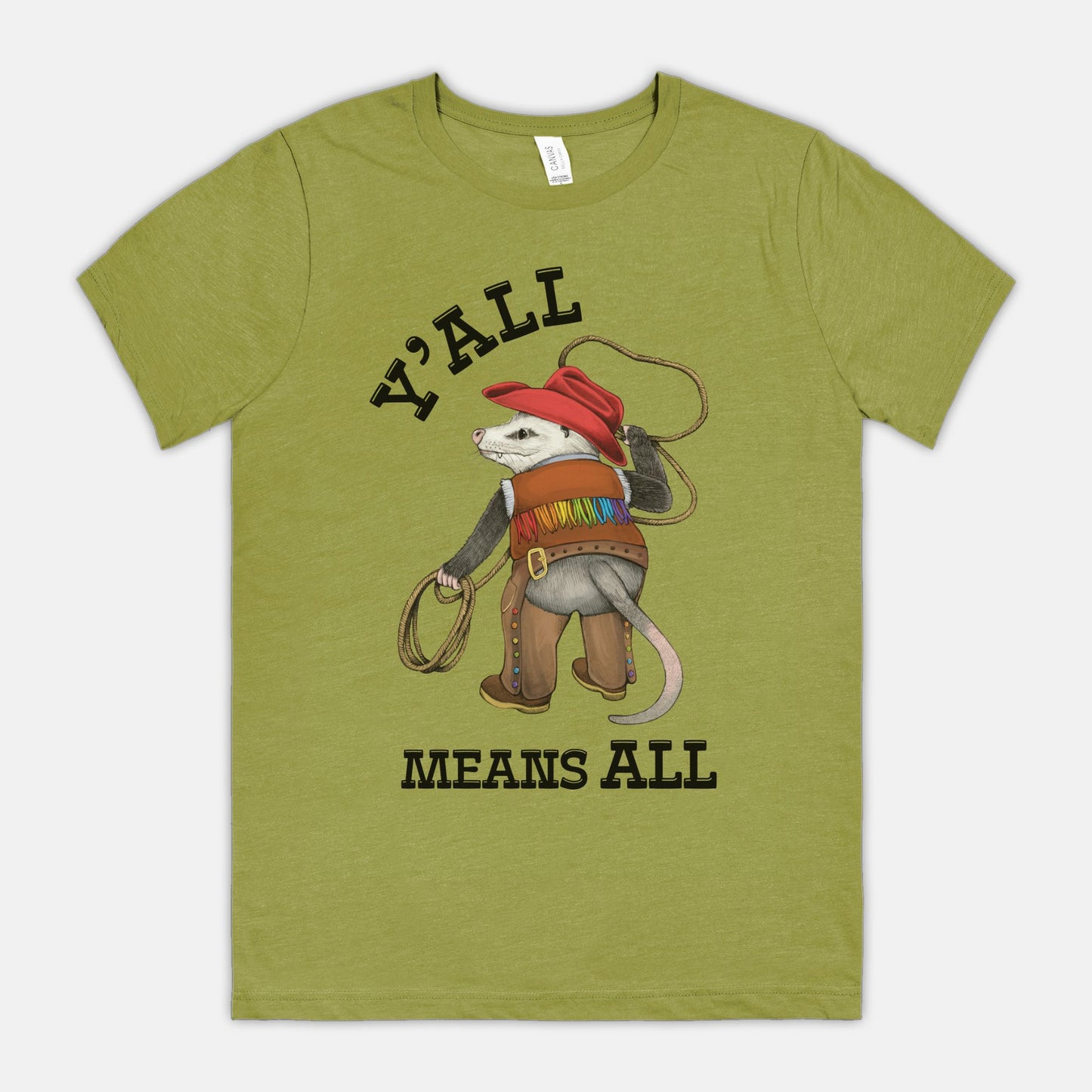 A green-colored shirt featuring a cowboy opossum and text reading “Y’all Means All”