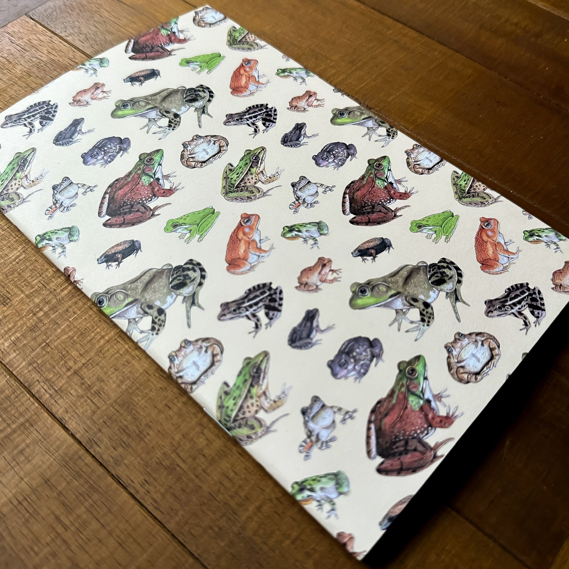 A handmade notebook featuring a pattern of frogs and toads