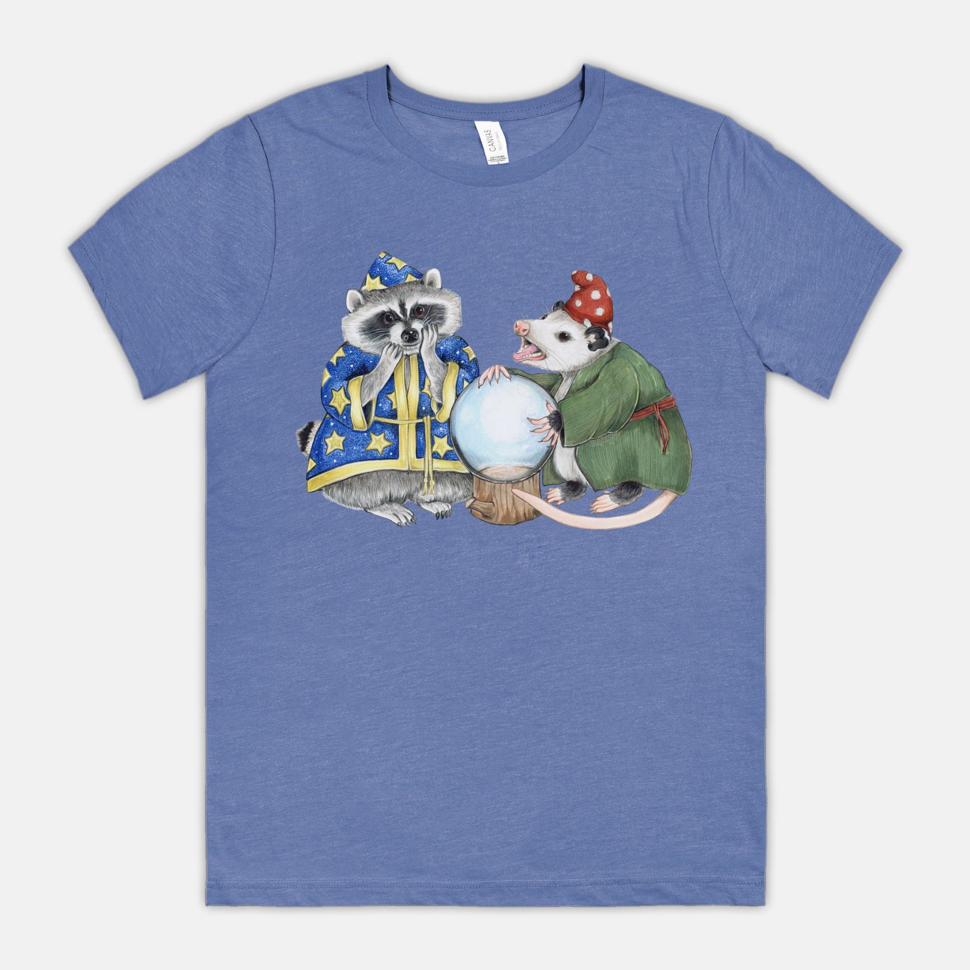 A blue t-shirt featuring an illustration of a raccoon wizard and opossum fortune teller