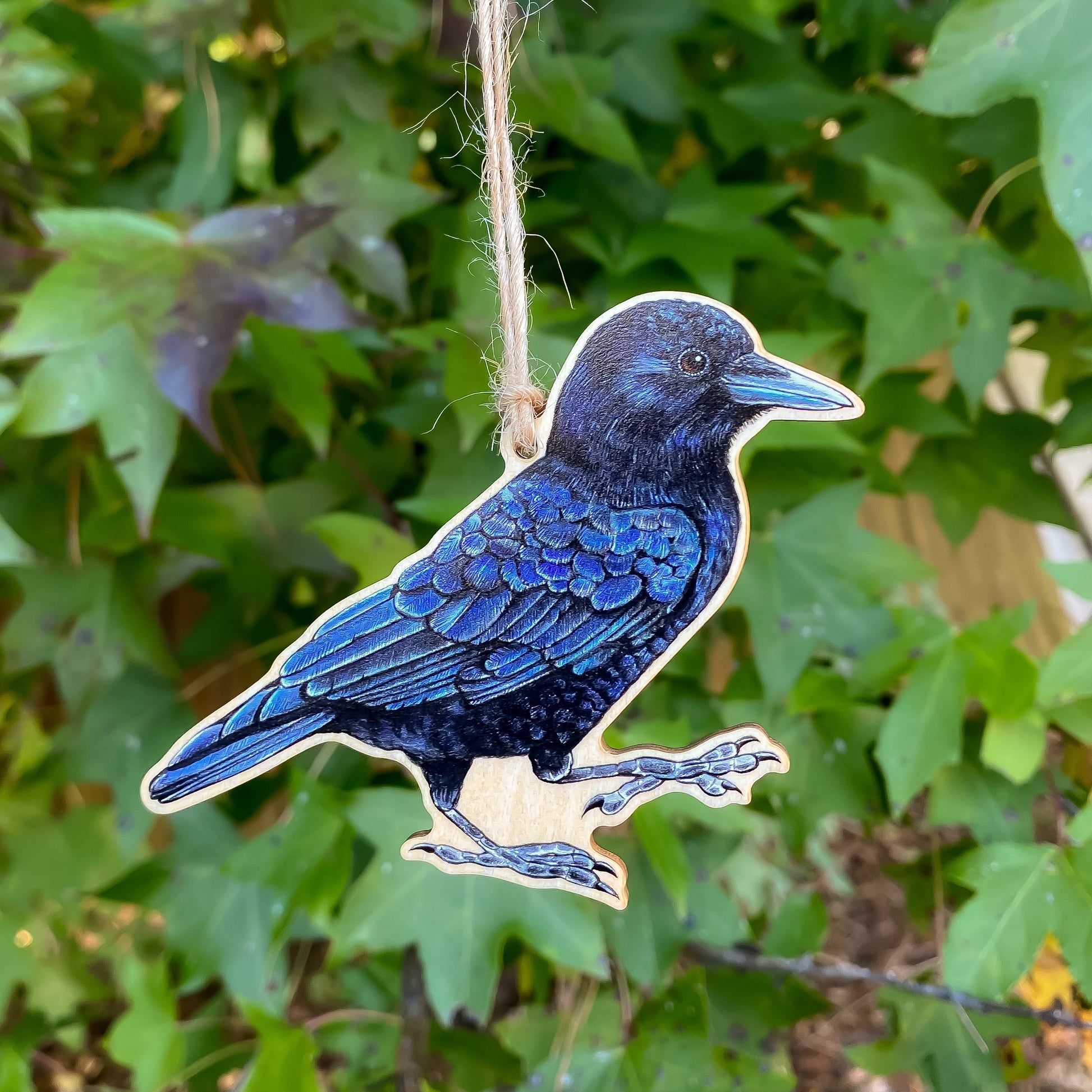 A wooden ornament strung with twine of an American crow.