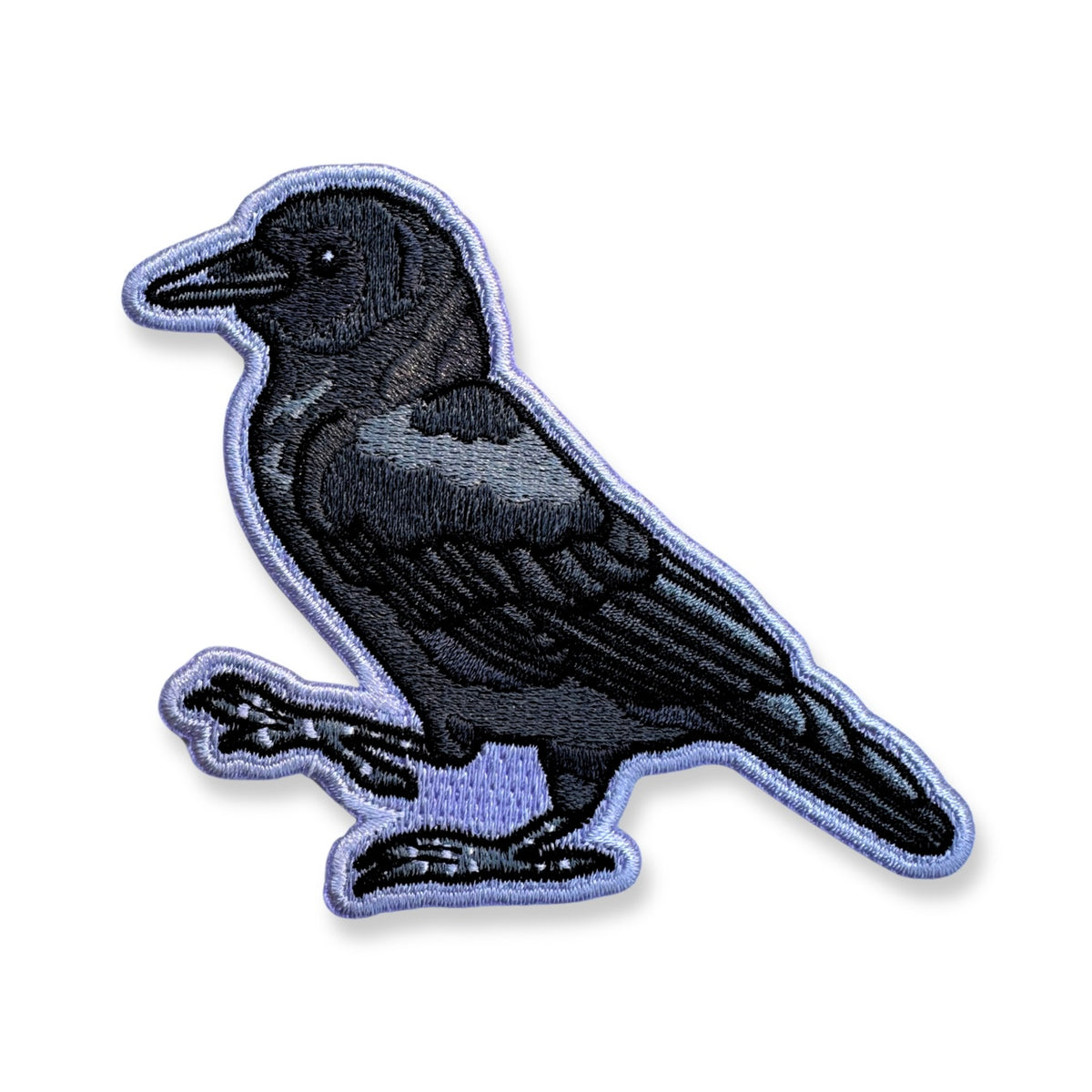 An embroidered patch of a crow, outlined in light purple, shown on a plain white background.