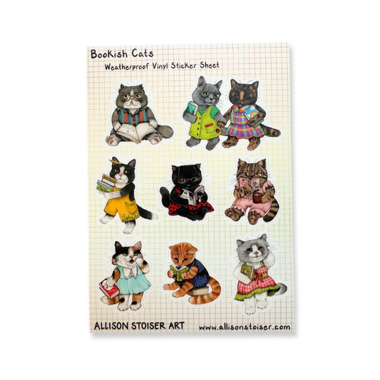 A sheet of vinyl stickers featuring nine bookish cats in various colorful outfits, printed on a cream-colored grid background.