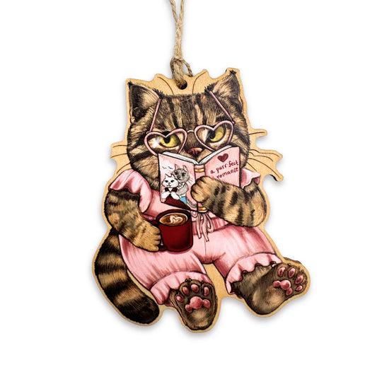 A wooden ornament of a cat reading a romance book