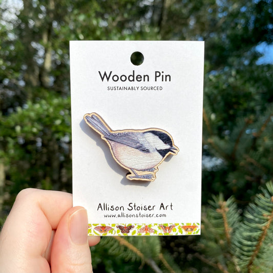 A wooden pin of a Carolina chickadee