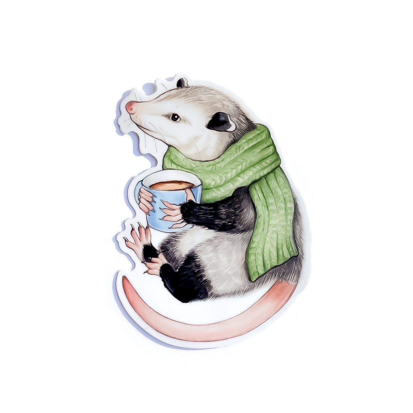 A weatherproof sticker featuring an illustration of a cozy opossum wearing a scarf and holding a mug of hot cocoa