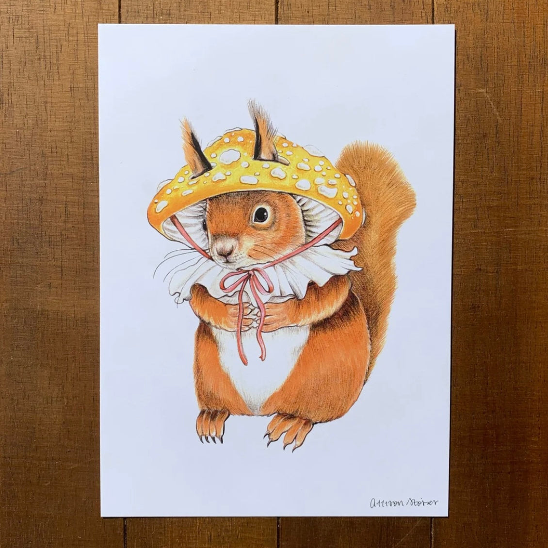 A print featuring a red squirrel wearing a mushroom hat