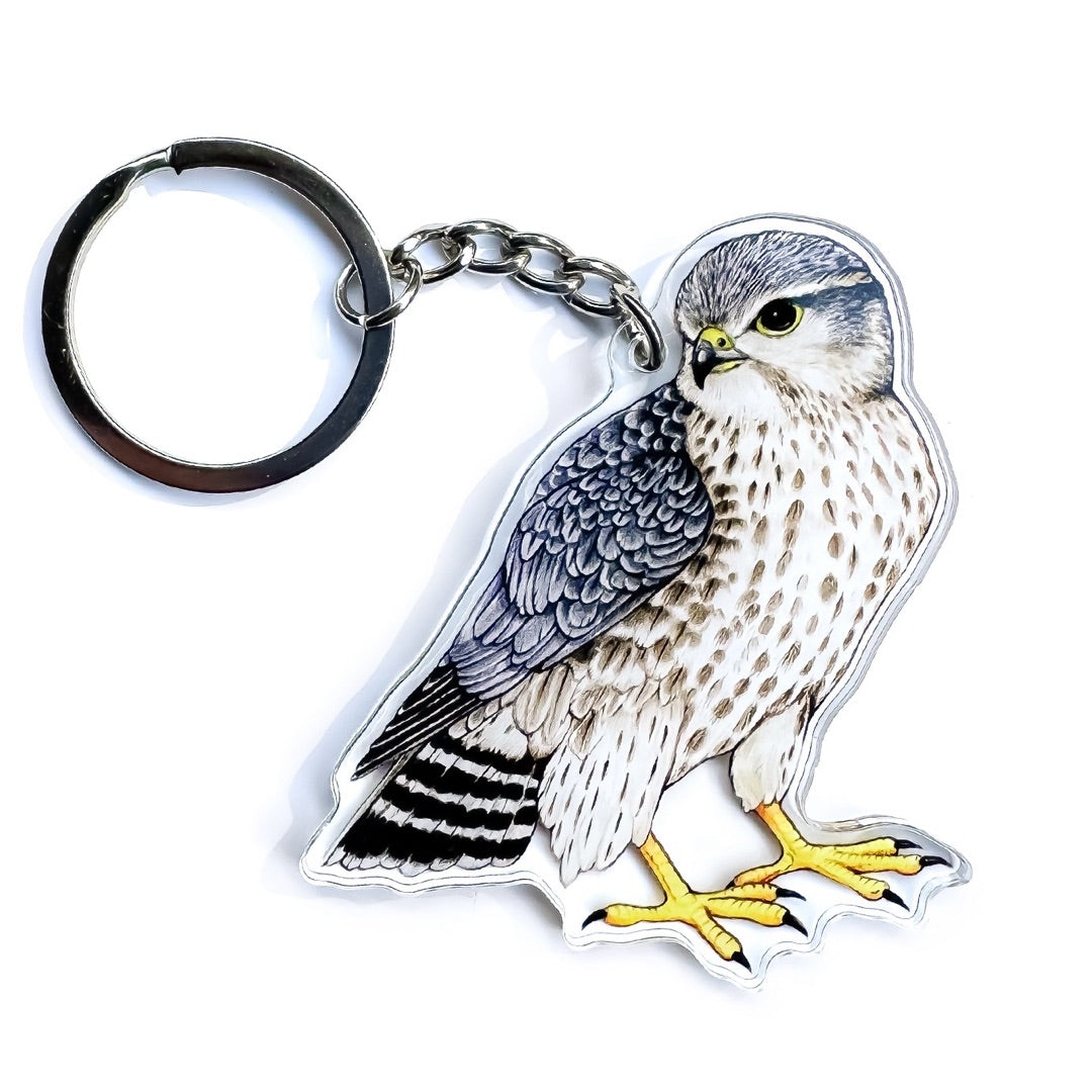 A keychain of a merlin on a white background.