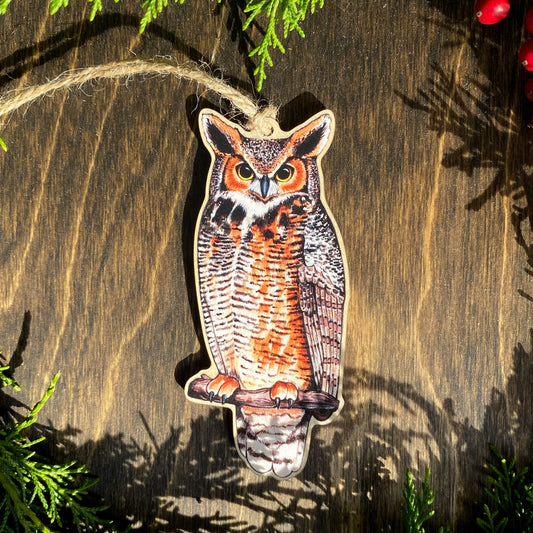 A wood print ornament featuring an illustration of a great horned owl