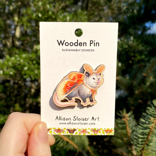 A wooden pin of an opossum dressed up as a flannel moth