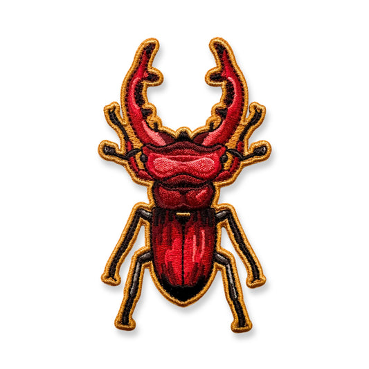 An embroidered patch of a giant stag beetle shown on a plain white background.