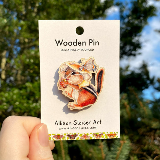 A wooden pin of a chipmunk with a honey mushroom hat