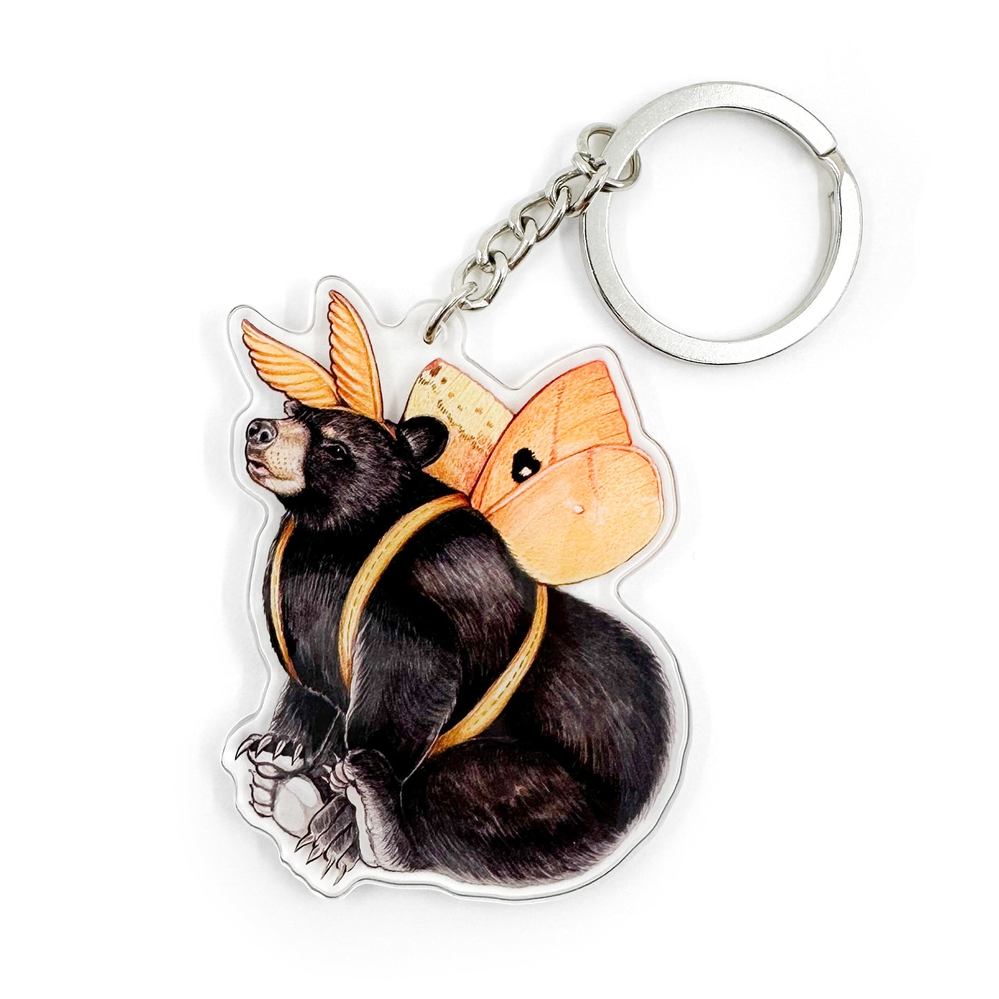 A keychain featuring an illustration of an American black bear dressed up like an io moth