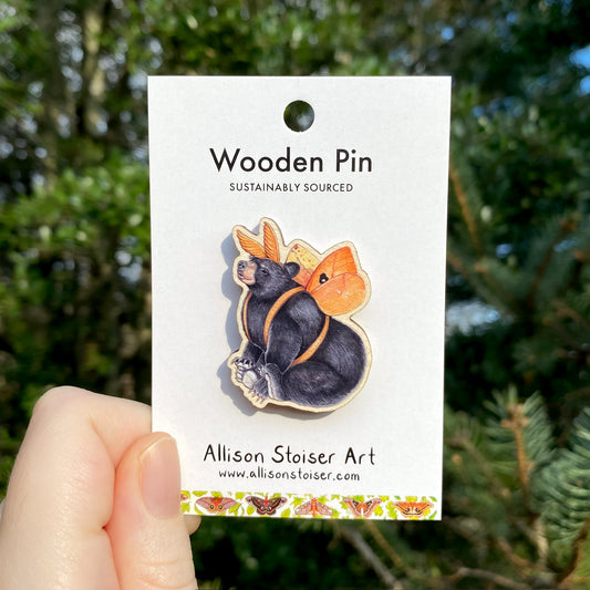 A wooden pin of a bear in an Io moth costume