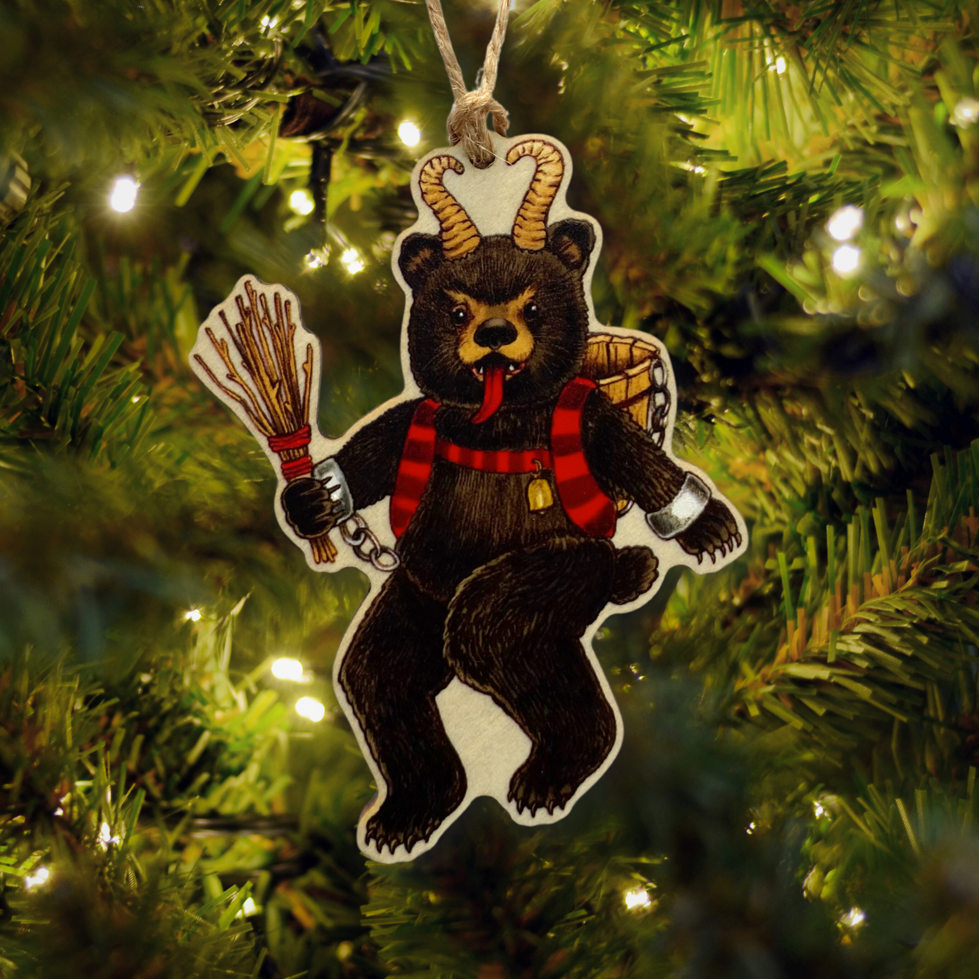 Decorative Krampus bear ornament with horns and a basket hanging on a Christmas tree.