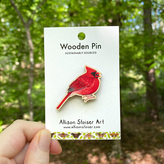 A wooden pin of a bright red northern cardinal