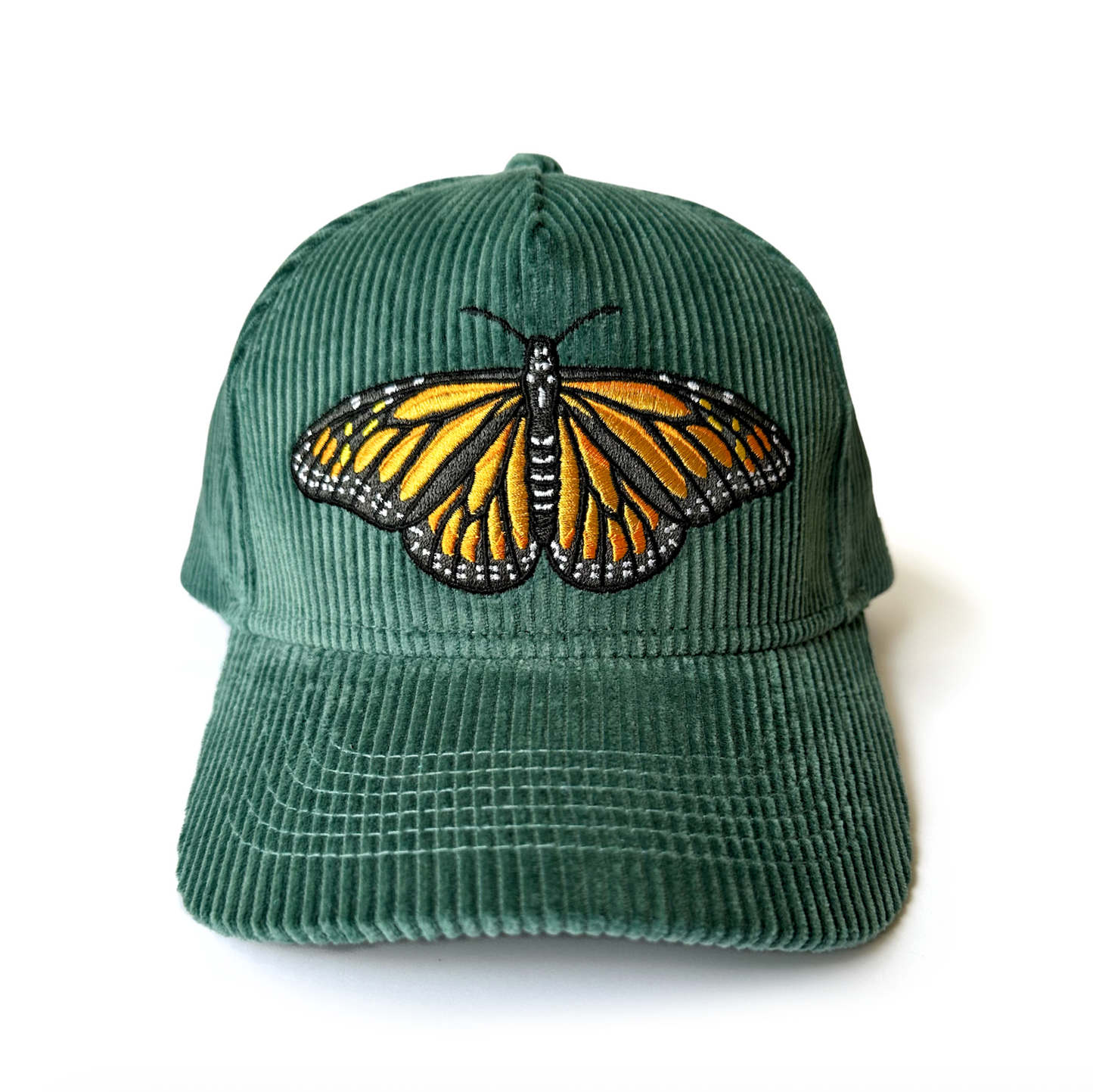 Green cap with an embroidered monarch butterfly on a white background