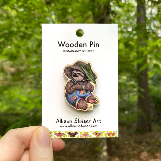 A wooden pin of a sloth in a mushroom hat